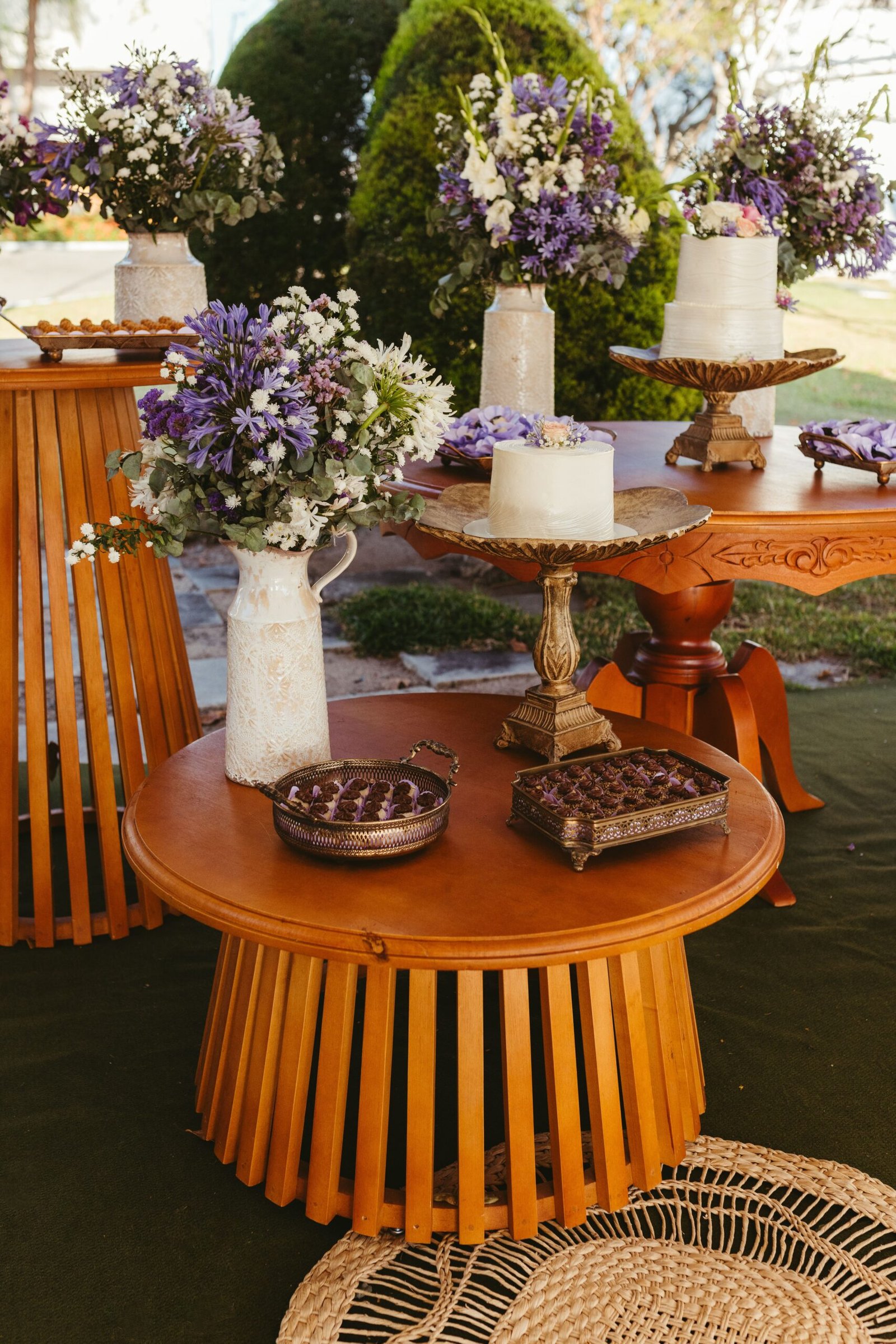 Charming outdoor setup of wooden tables adorned with floral arrangements and elegant decor.